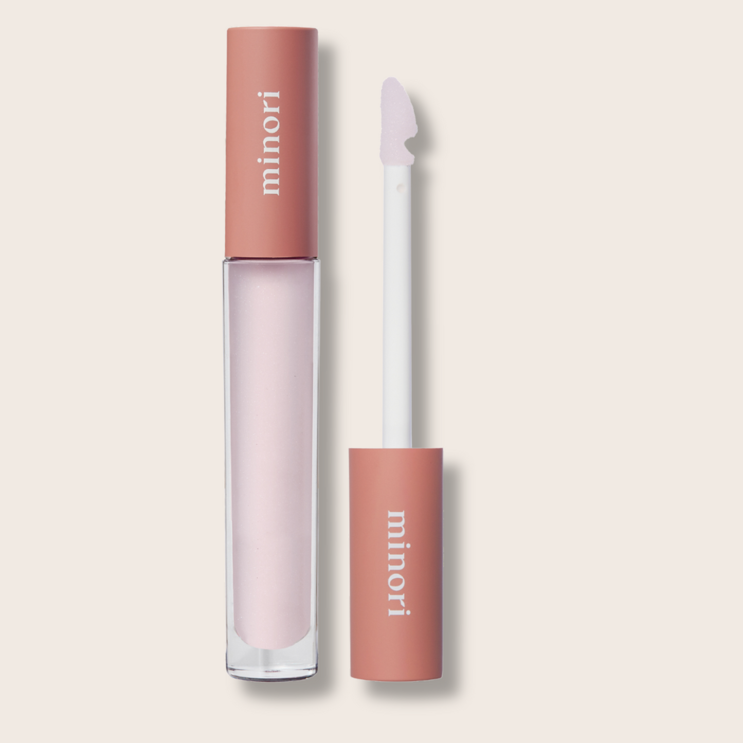 Lip gloss with applicator on a beige background, featuring the brand 'minori'.