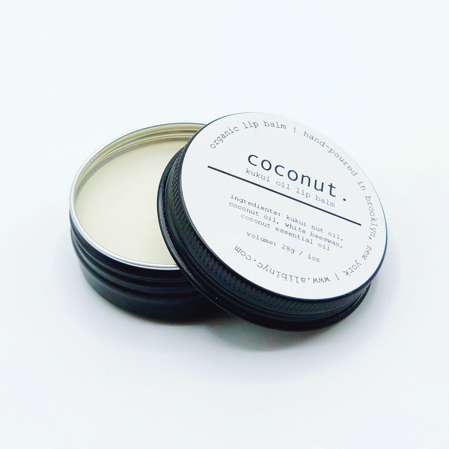 Coconut scented product in a black container with a white label on a white background