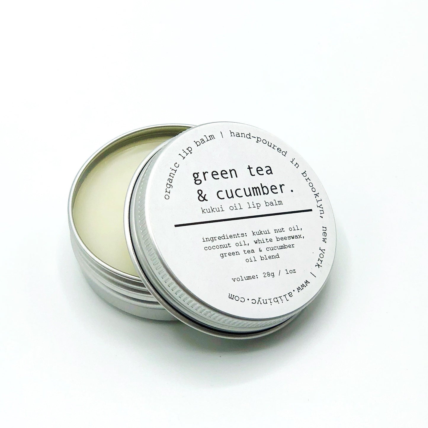 Tin of green tea and cucumber lip balm on a white background