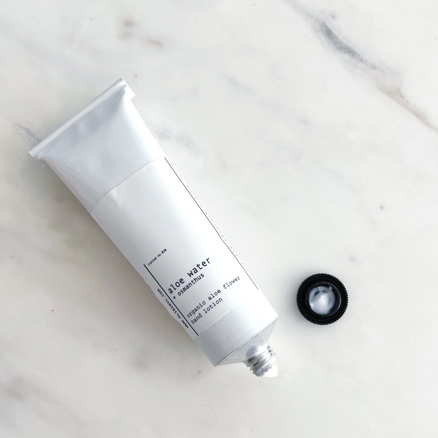 White tube of handcreem on a marble surface