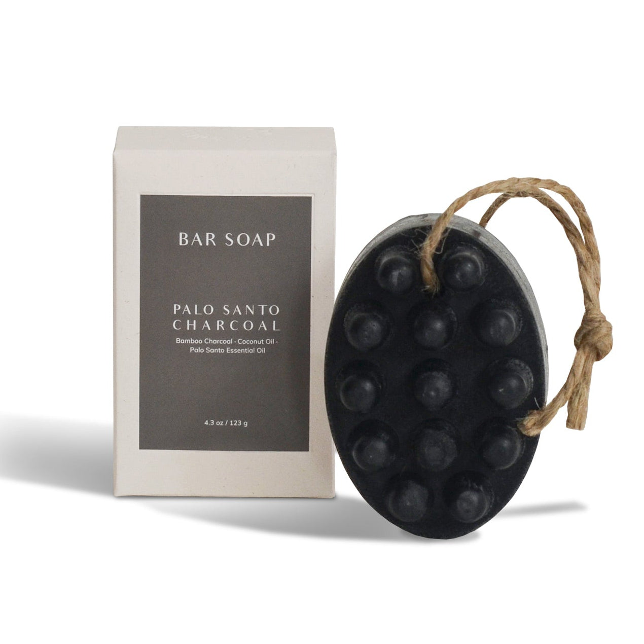 Black bar soap on a rope with packaging labeled 'Palo Santo Charcoal' on a white background