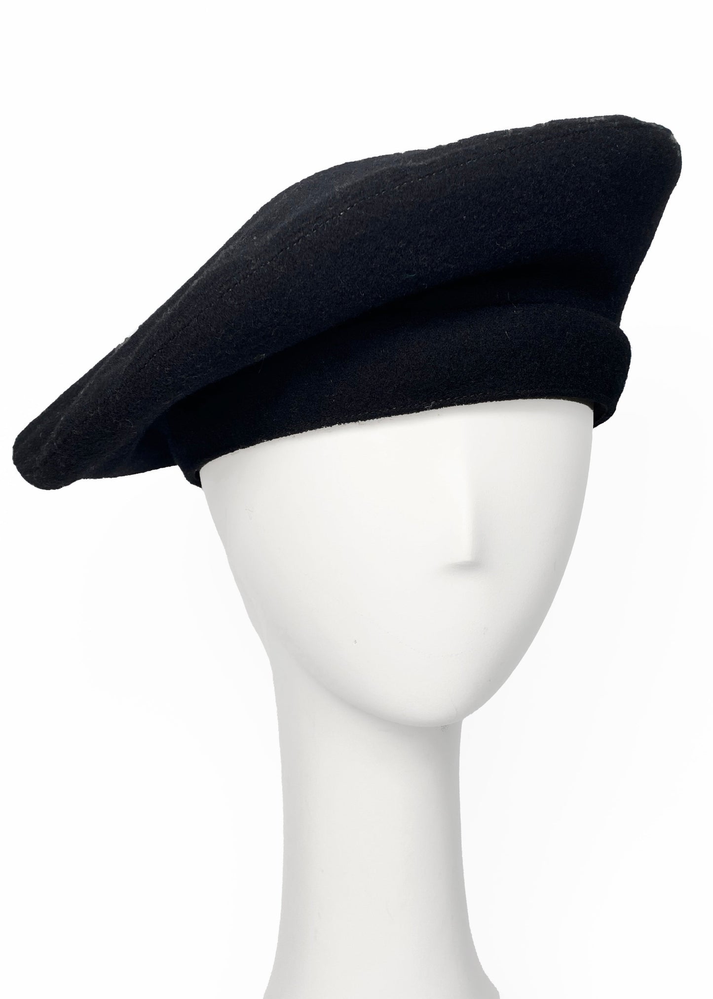Black beret on a mannequin head against a white background