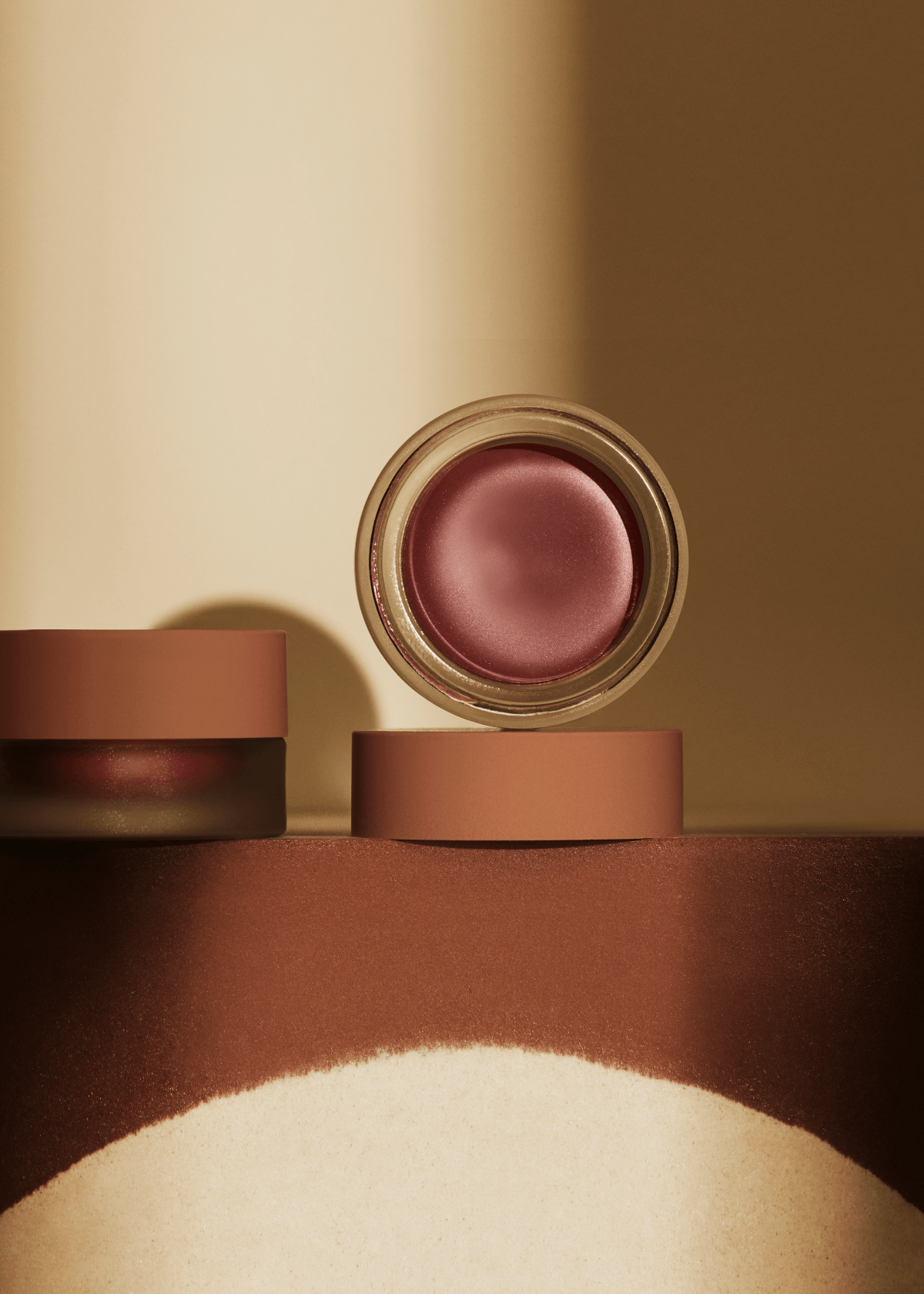 Cosmetic product with a pink shade on a brown surface
