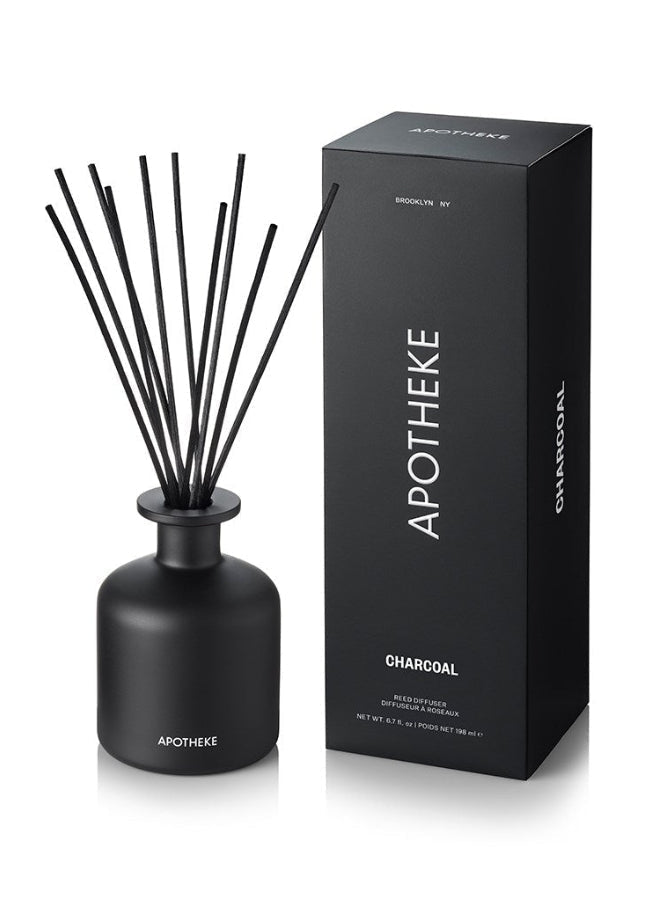 Black diffuser bottle with reeds and packaging on a white background