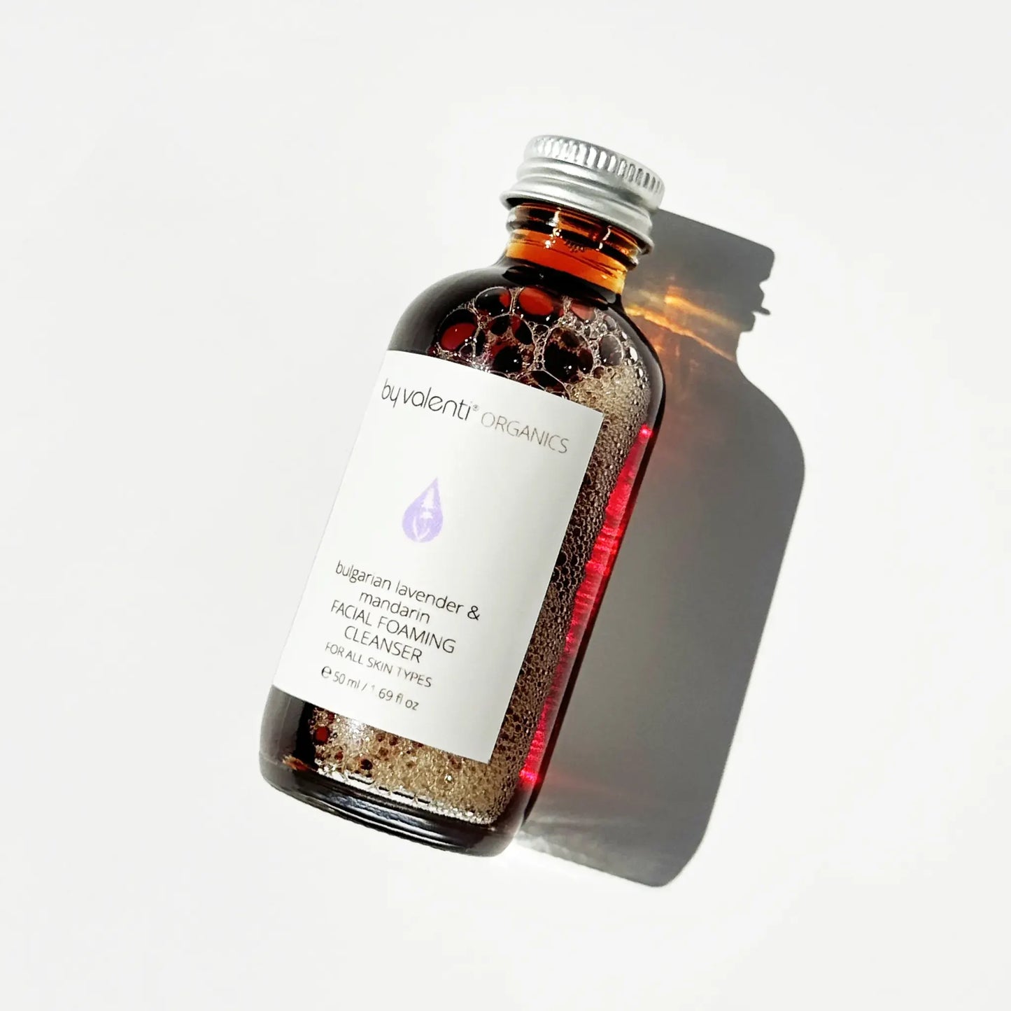 Bottle of Bulgarian Lavender & Mandarin facial cleanser with a white label on a light gray background