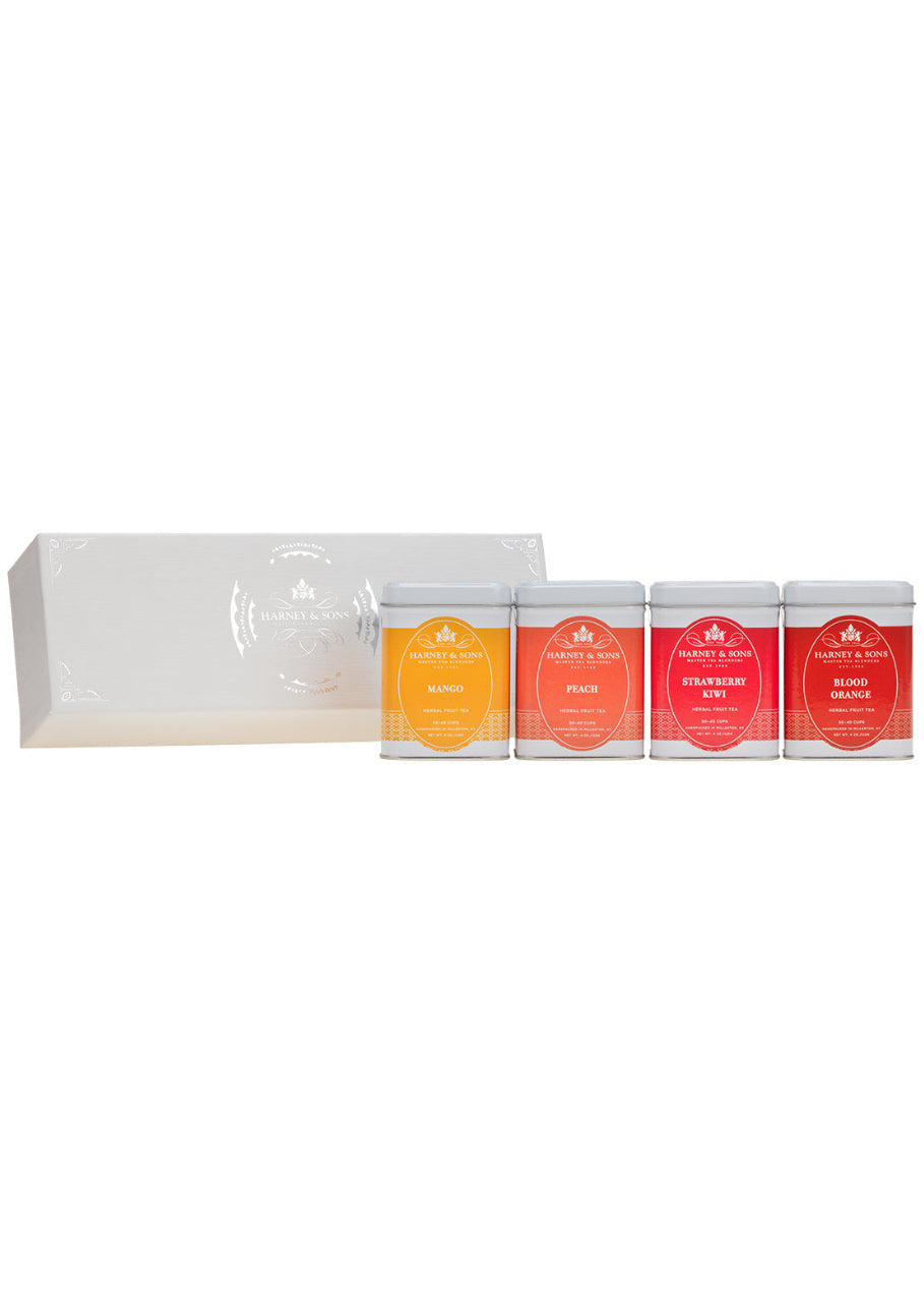 Set of four tea tins with colorful labels and a white box on a white background