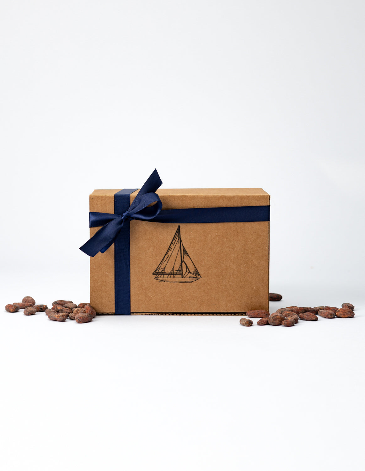 Brown gift box with navy ribbon and sailboat design on a white background