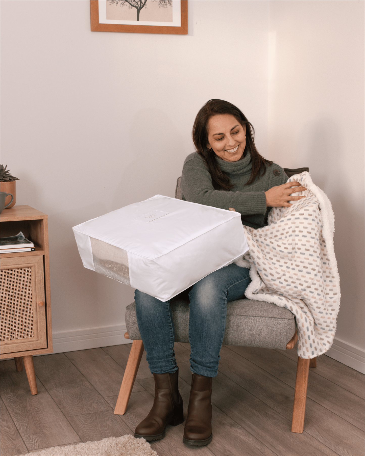 Woman showing the size of the white cotton cube on her lap for proportion reference. 