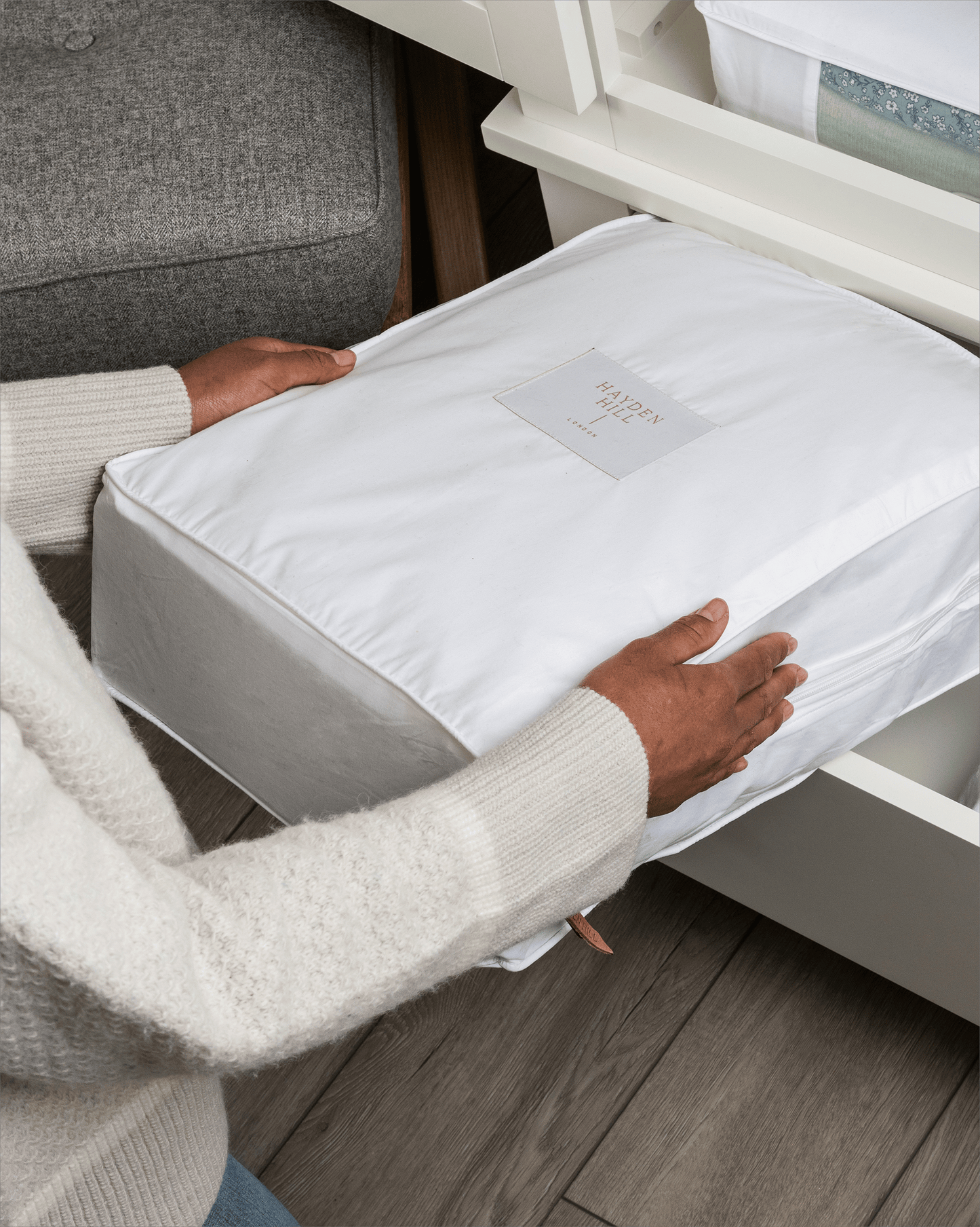 Person placing a white cotton cube in the drawer