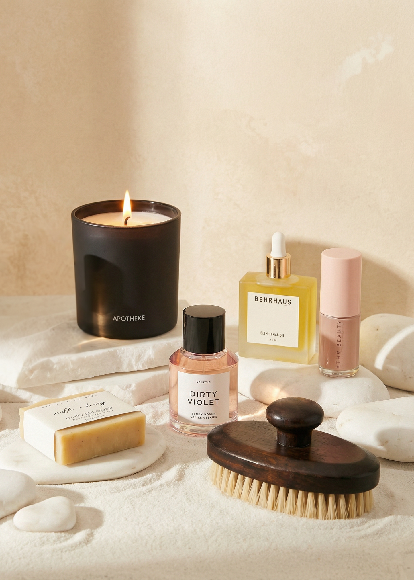 Collection of bath and body products including a candle, soap, and bottles on a neutral background