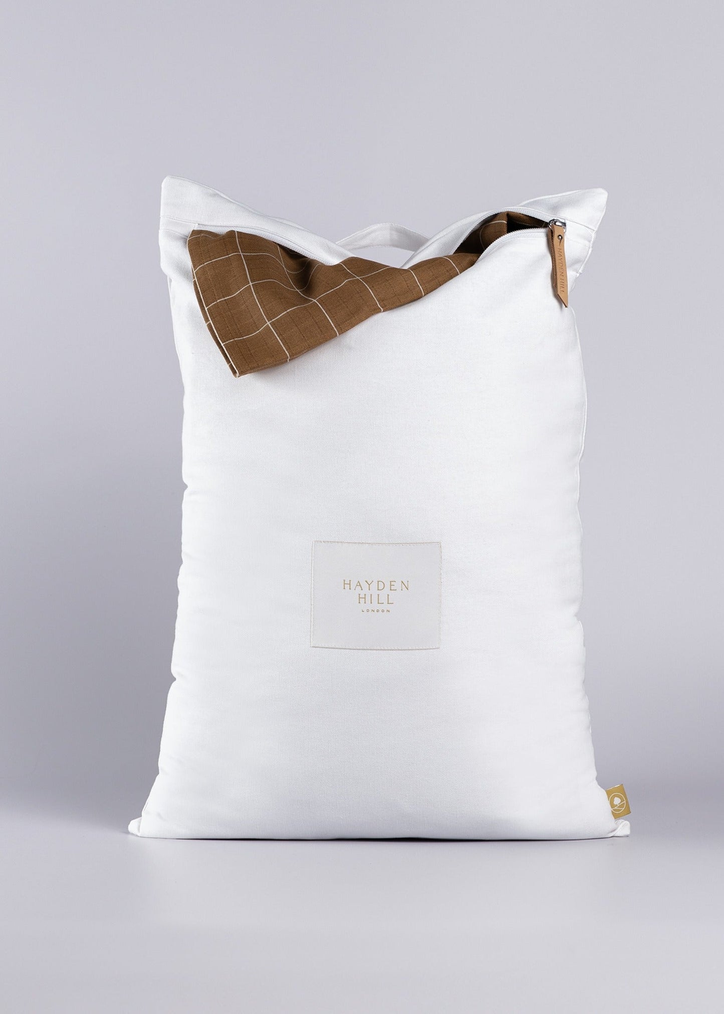 White laundry bag garment sticking out on a light background. 