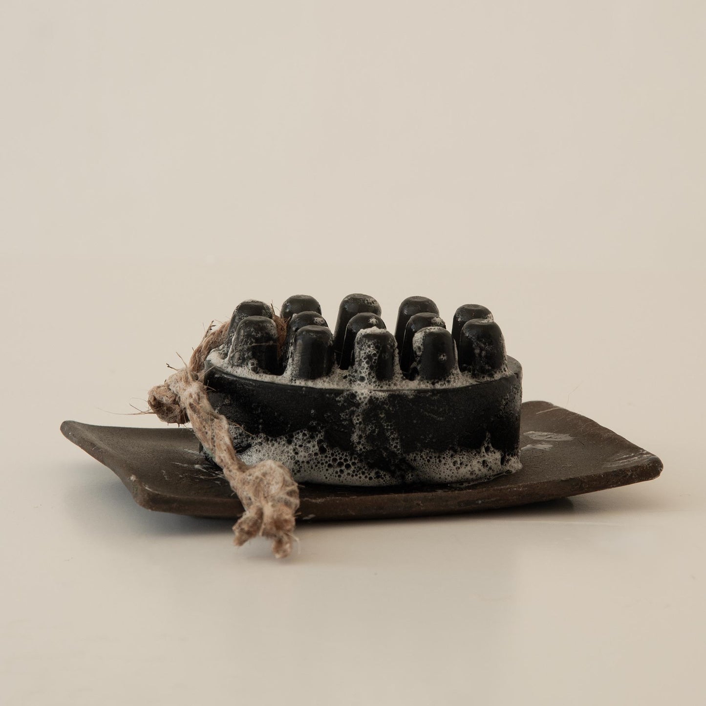 Image of charcoal soap on a ceramic soap dish 