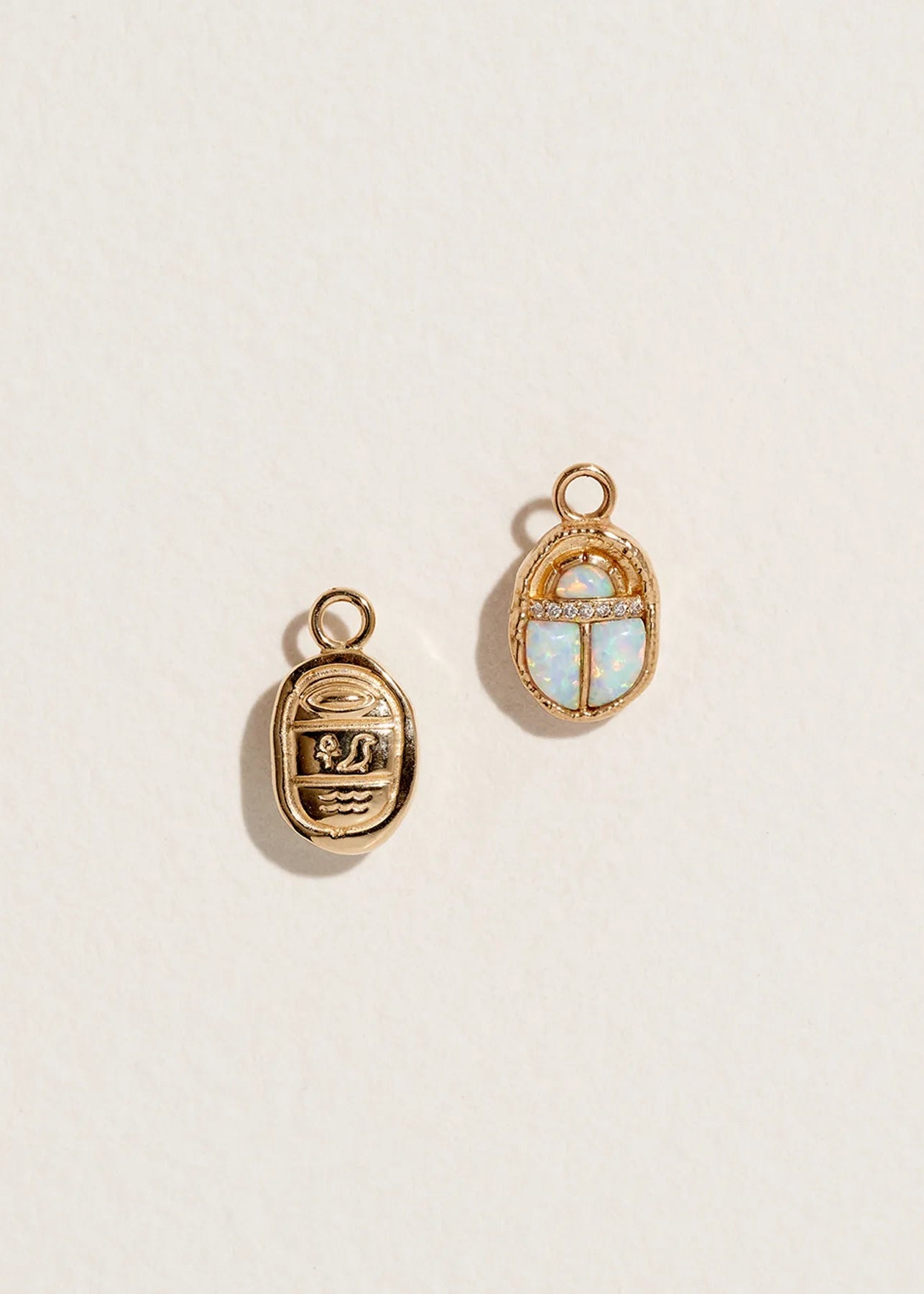 14K gold scarab charm pendant with pave dimonds and opal stones. The reverse side shows Egyptian hieroglyphs.