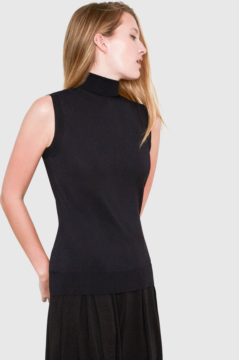 Sleeveless viscose sweater in black features a sleek turtleneck and is made of luxurious Italian yarn. 